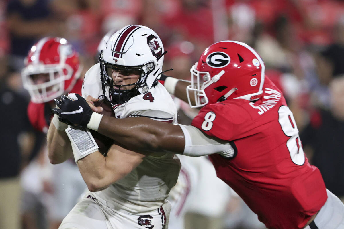 South Carolina quarterback Luke Doty (4) is tackled by Georgia linebacker MJ Sherman (8) during ...