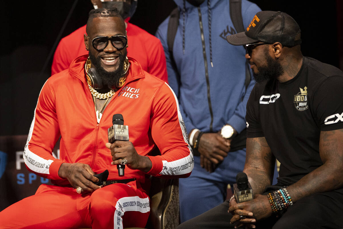 Deontay Wilder, left, speaks to his trainer, Malik Scott, during a news conference in advance o ...