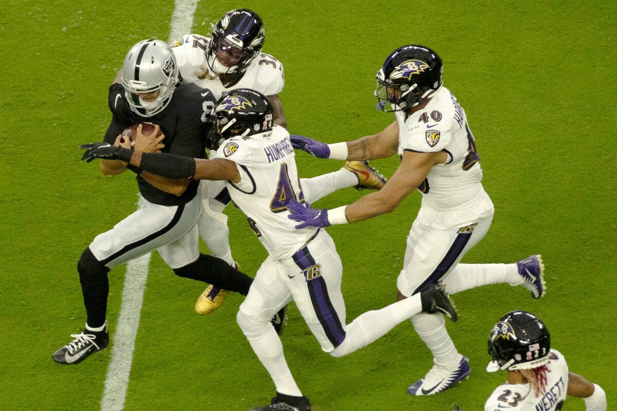 Raiders quarterback Marcus Mariota (8) rushes against the Ravens defense during an NFL football ...