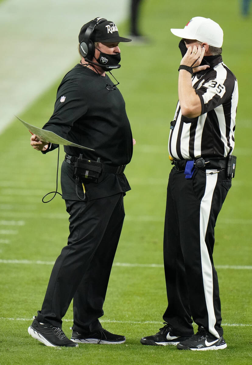 Las Vegas Raiders head coach Jon Gruden talks with referee John Hussey #35 during the third qua ...