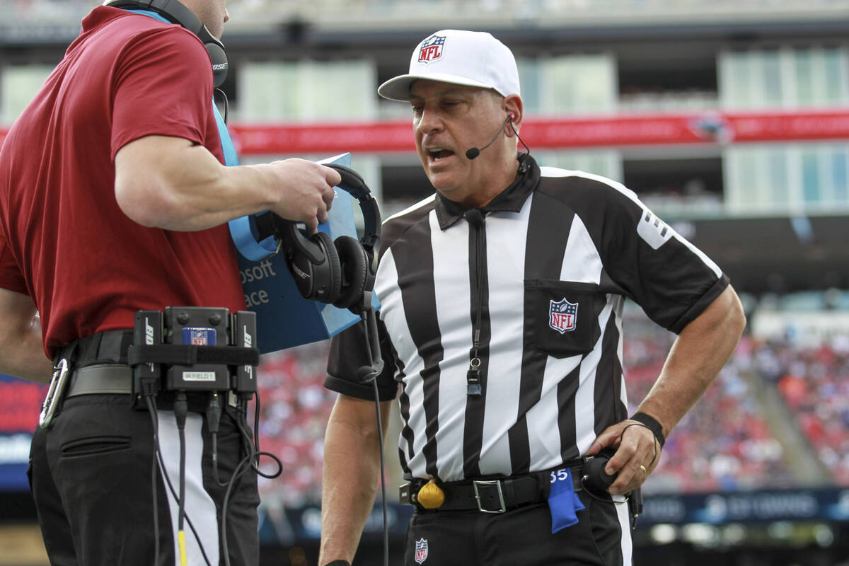 Referee John Hussey (35) reviews a play using instant replay during the first half an NFL footb ...