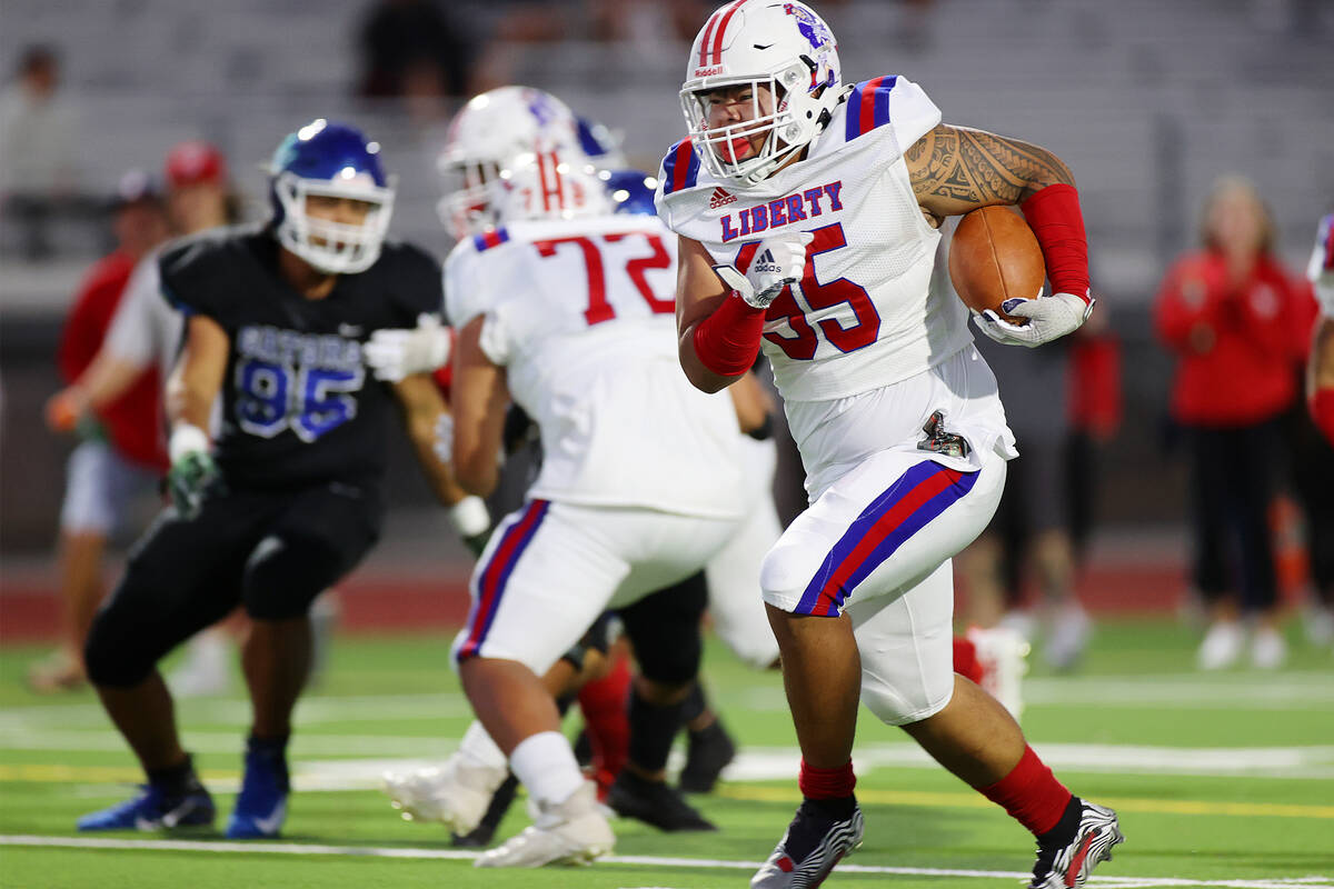 Liberty's Jayven Perez (95) runs the ball for a touchdown in the first half of a football game ...