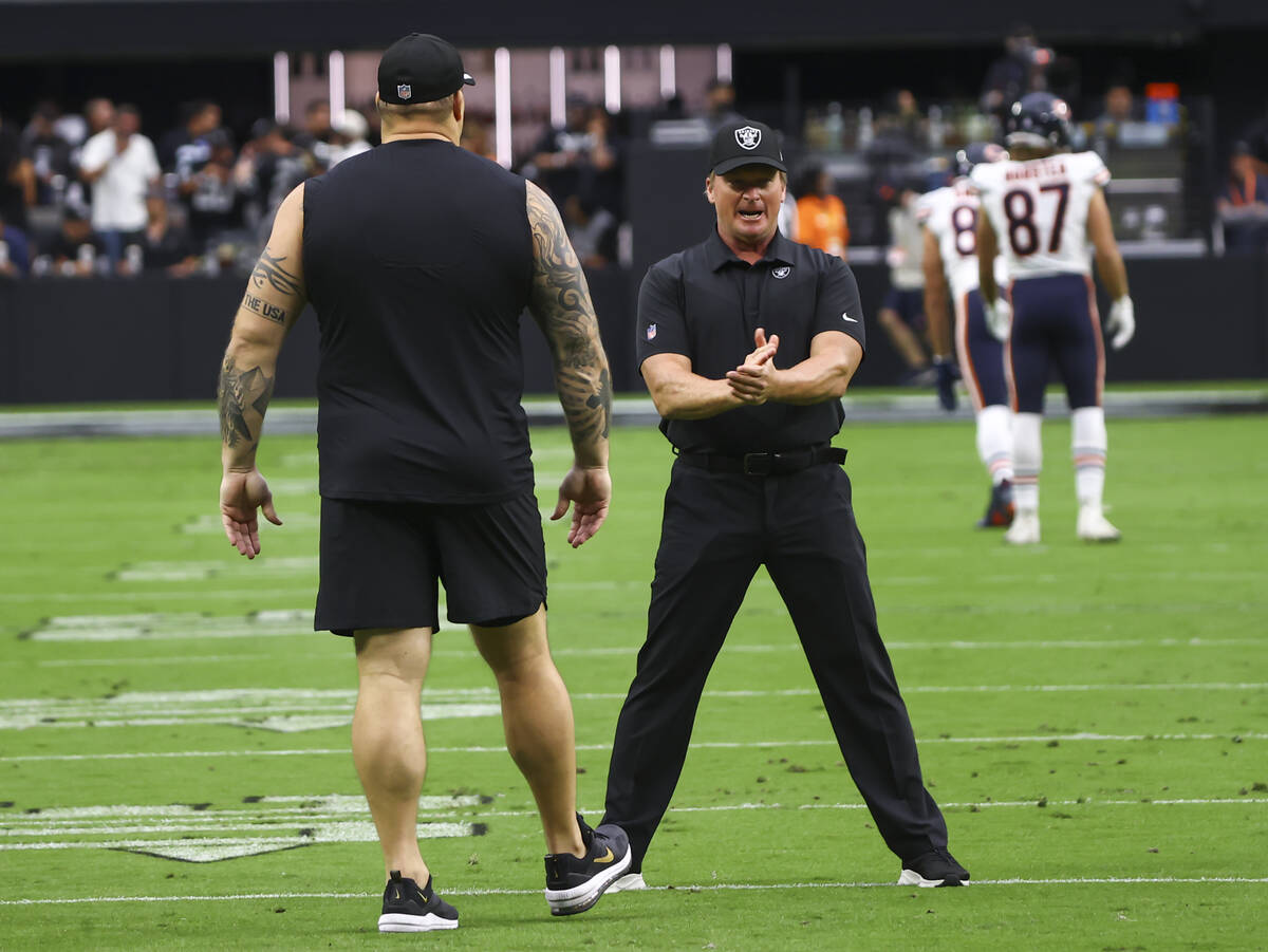 Raiders head coach Jon Gruden looks talks with offensive guard Richie Incognito on before the s ...