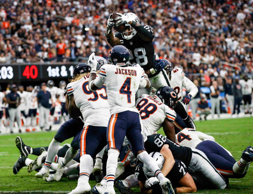 Raiders running back Josh Jacobs (28) leaps over to score a touchdown against the Chicago Bears ...