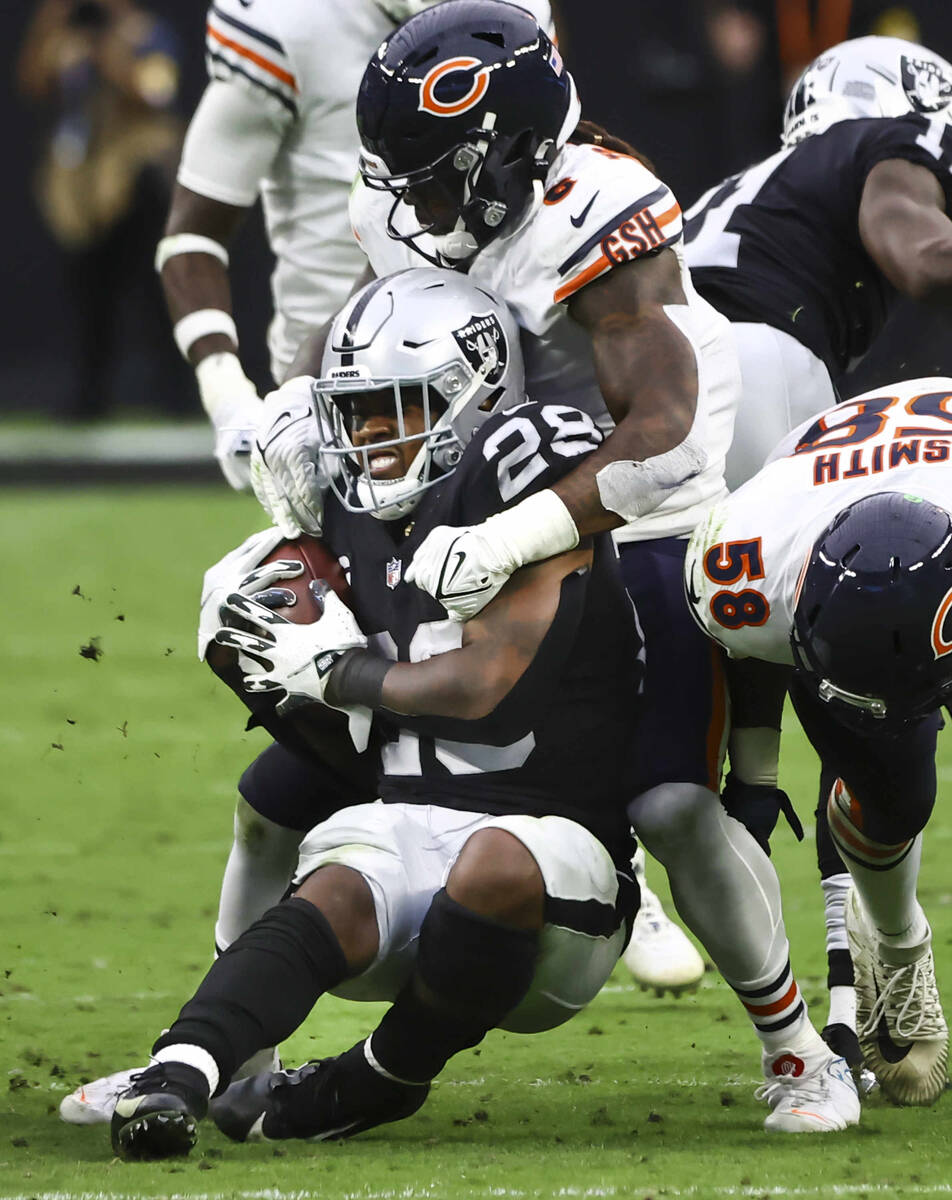 Raiders running back Josh Jacobs (28) gets stopped by Chicago Bears linebacker Danny Trevathan ...