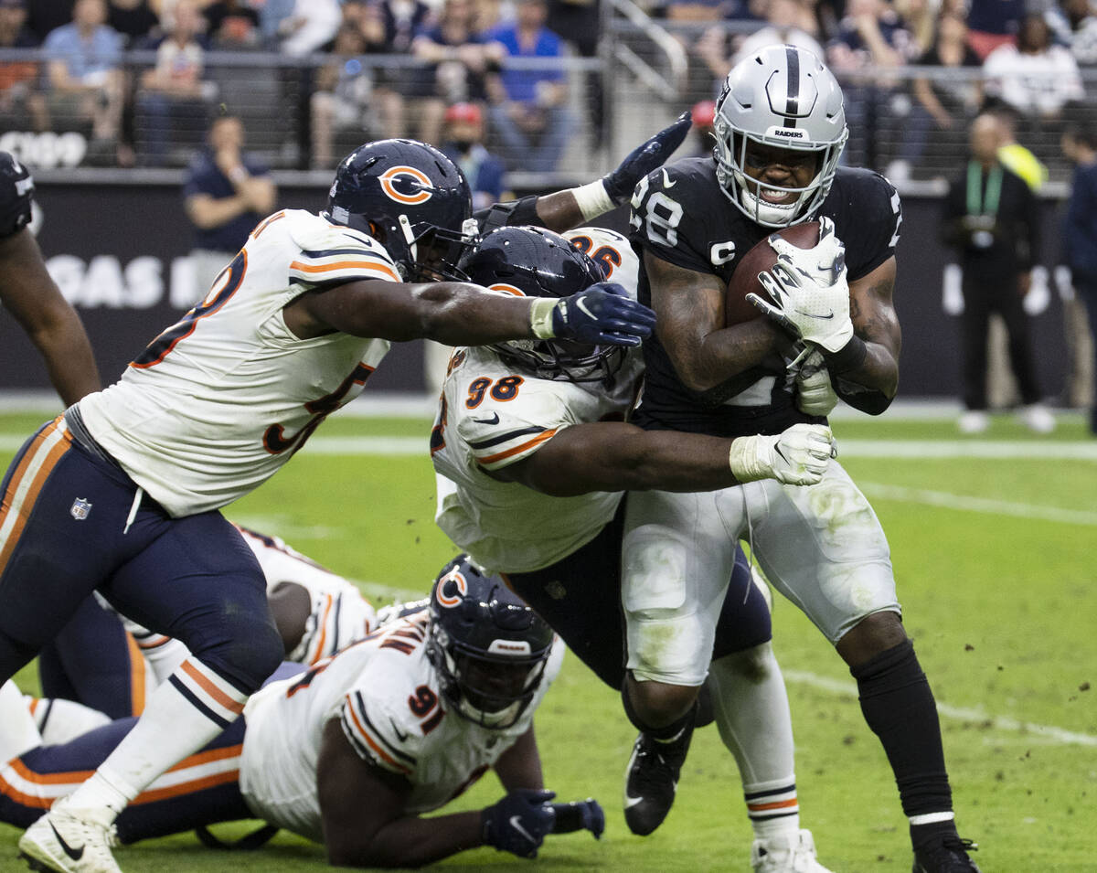 Raiders running back Josh Jacobs (28) tackled by Chicago Bears defenders during the second half ...