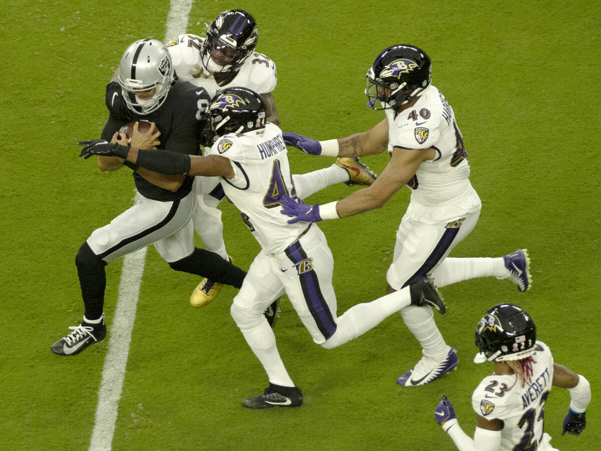 Raiders quarterback Marcus Mariota (8) rushes against the Ravens defense during an NFL football ...