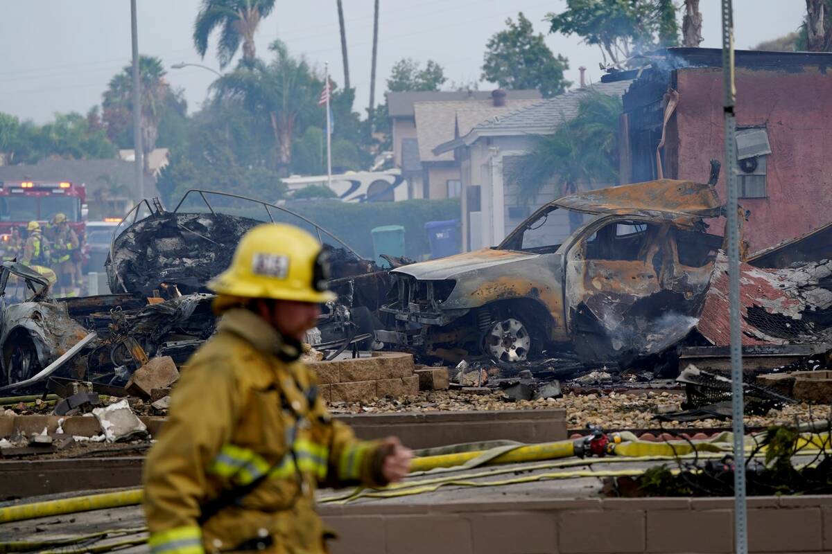 Fire crews work the scene of a small plane crash, Monday, Oct. 11, 2021, in Santee, Calif. (AP ...