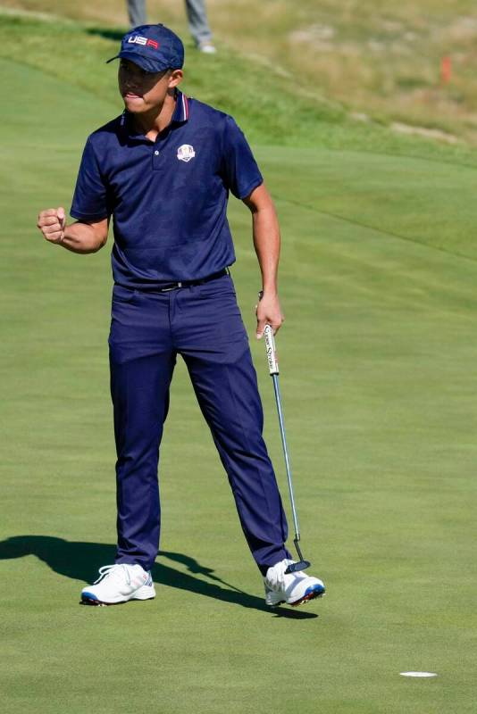 Team USA's Collin Morikawa reacts after making a putt on the 17th hole during a foursomes match ...