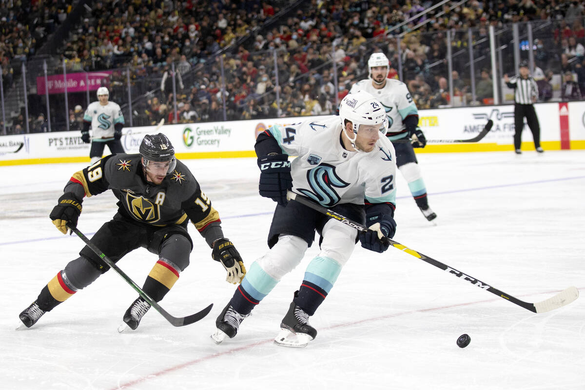 Golden Knights right wing Reilly Smith (19) skates for the puck behind Kraken defenseman Jamie ...