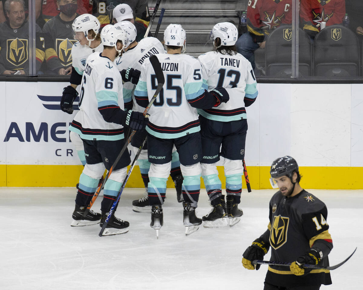 Seattle Kraken players celebrate after scoring a goal as Vegas Golden Knights defenseman Nicola ...