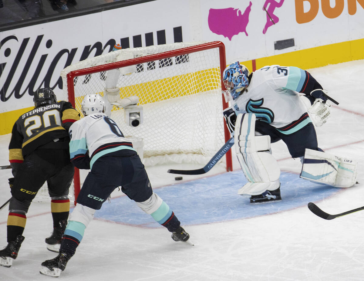 Vegas Golden Knights center Chandler Stephenson (20) scores a goal against Seattle Kraken goalt ...