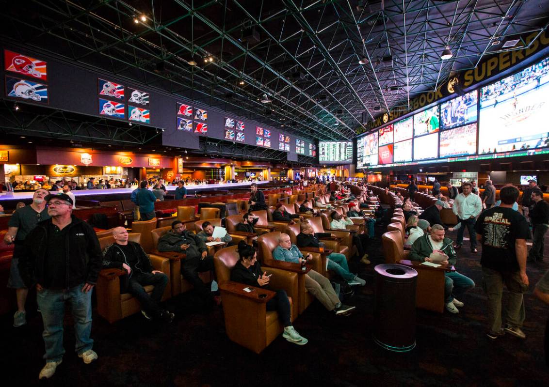 Bettors look at the displays of prop bets for the Super Bowl at the Westgate Superbook in Las V ...