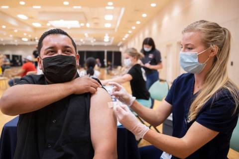 Jose Padilla, left, getÕs his COVID-19 vaccination from Touro University Nevada physician ...
