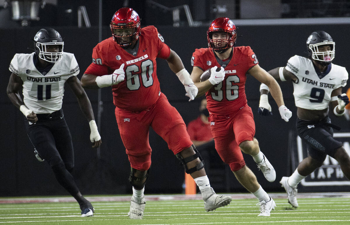 UNLV Rebels running back Chad Magyar (36) rushes up field past Utah State Aggies defensive end ...