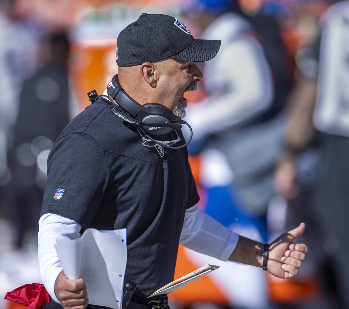 Raiders interim head coach Rich Bisaccia yells to players on the bench versus the Denver Bronco ...