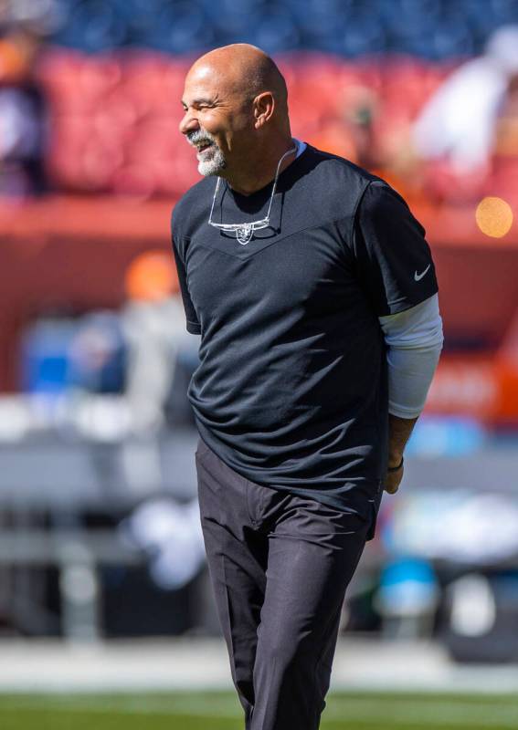 Raiders interim head coach Rich Bisaccia laughs with players before the first half of an NFL ga ...