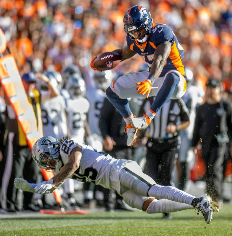 Denver Broncos running back Javonte Williams (33) jumps over the Raiders' free safety Trevon Mo ...