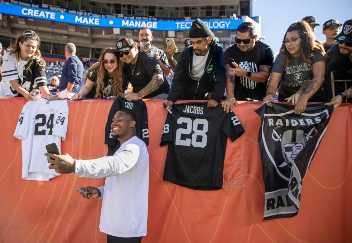 Raiders running back Josh Jacobs (28) takes a selfie with fans while signing autographs before ...
