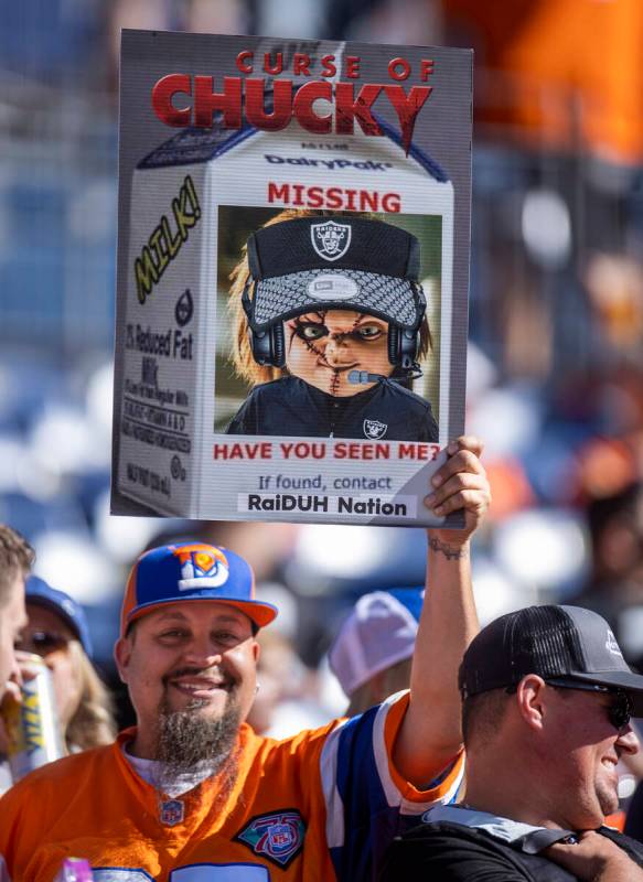 A Denver Broncos fan holds a sign about Jon Gruden during the first half of an NFL game at Emp ...