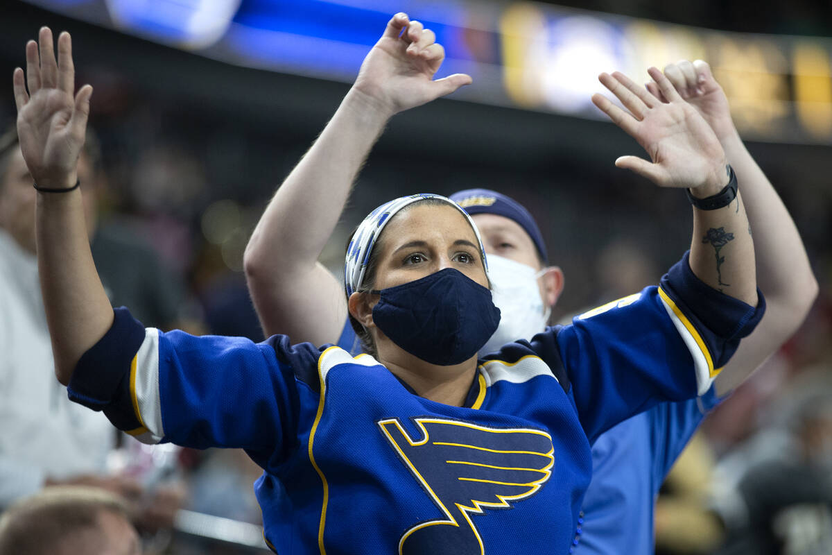 Blues fans celebrate the third goal for their team during the third period of a NHL hockey game ...