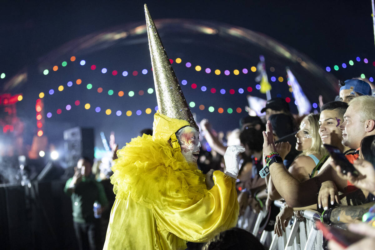 A costumed performer greets people in the crowd as Kaskade performs at the Kinetic Field stage ...