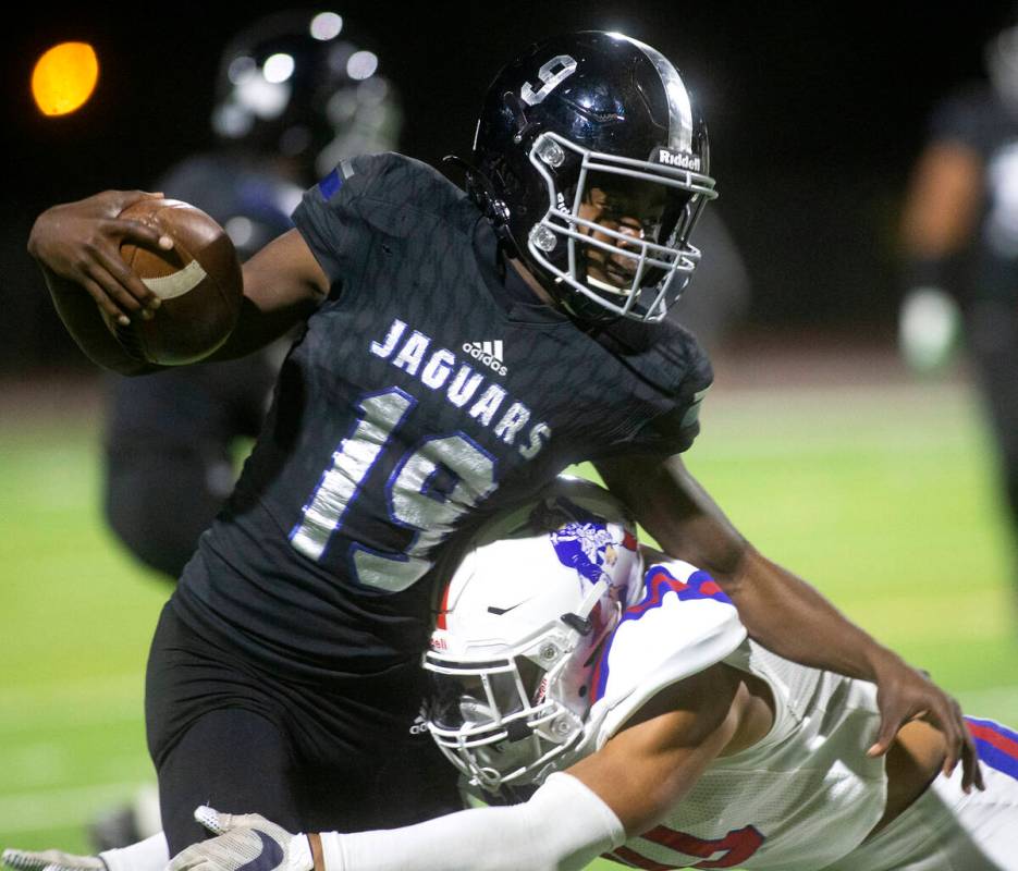 Desert Pines' Billy Ross (19) is tackled by Liberty's Cliffton Weber (10) during the first half ...