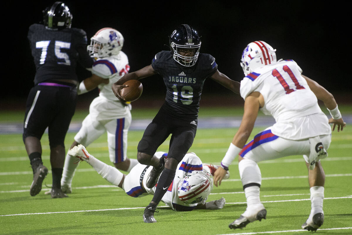 Desert Pines' Billy Ross (19) runs with the ball as Liberty's Kahekili Paaoao (11) defends duri ...