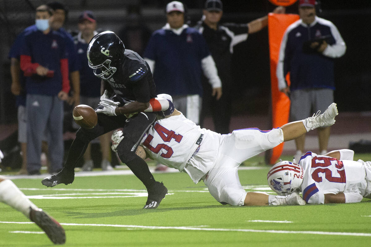 Desert Pines' Ferrari Busby (6) fumbles the ball as Liberty's Tristan Tucay (54) and Ashtin Kek ...