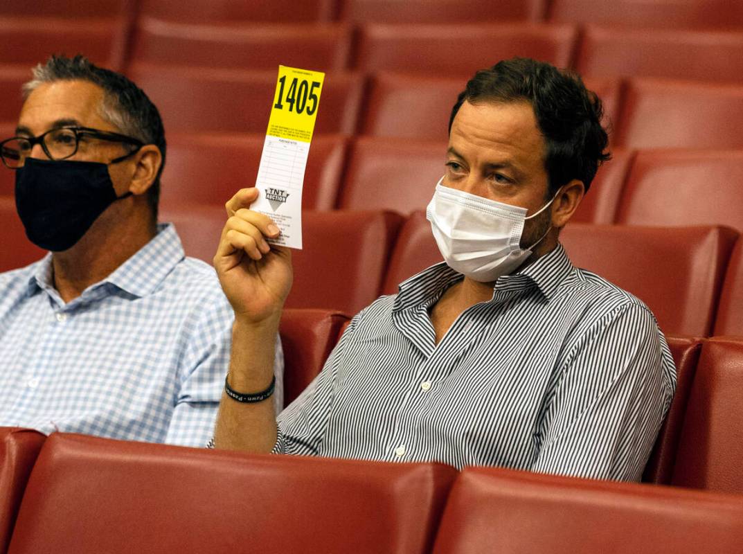 A bidder raises his number for a bid during the 25th pawnbroker license auction at the City Hal ...