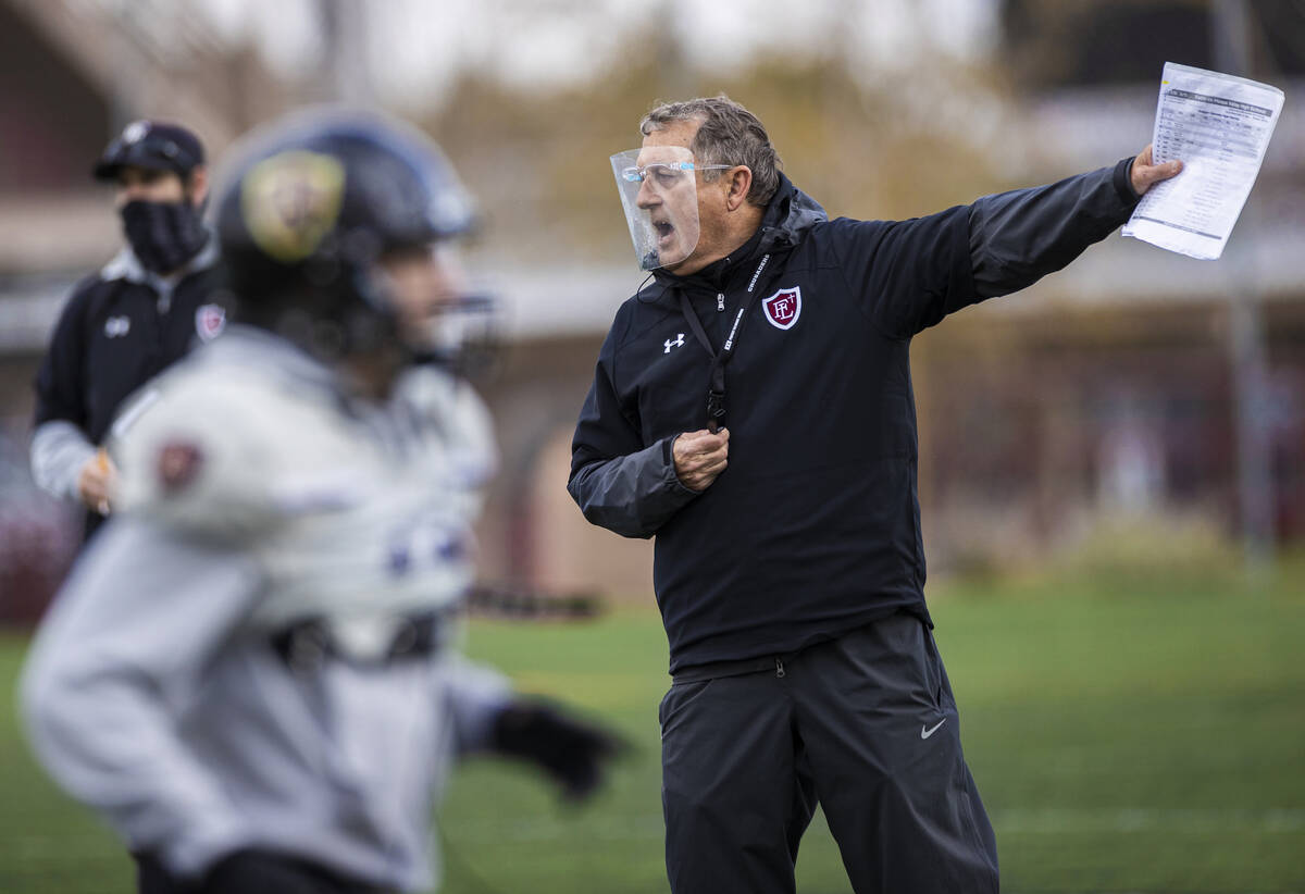 In this March 11, 2021, file photo, Faith Lutheran head football coach Mike Sanford, right, lea ...