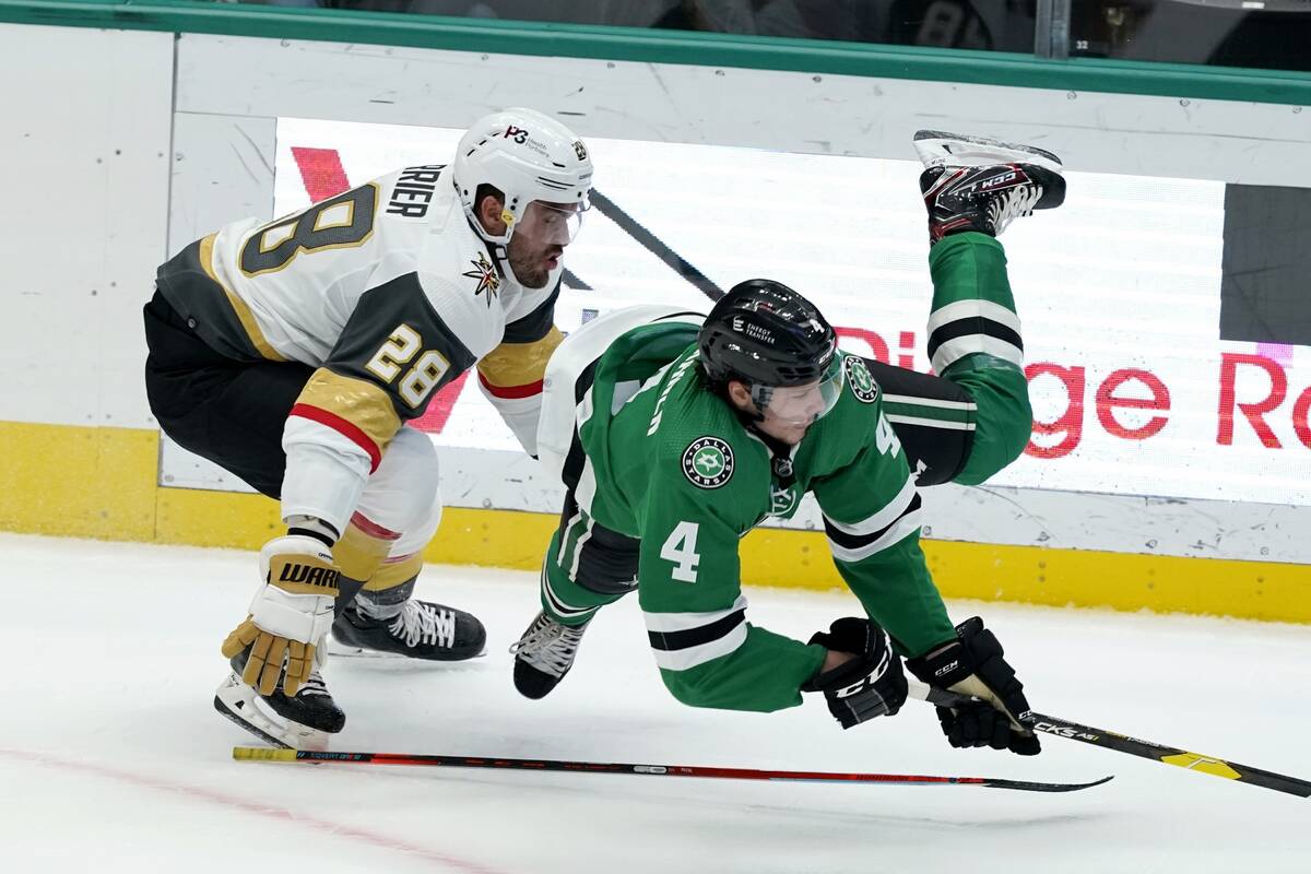 Vegas Golden Knights left wing William Carrier (28) trips Dallas Stars defenseman Miro Heiskane ...