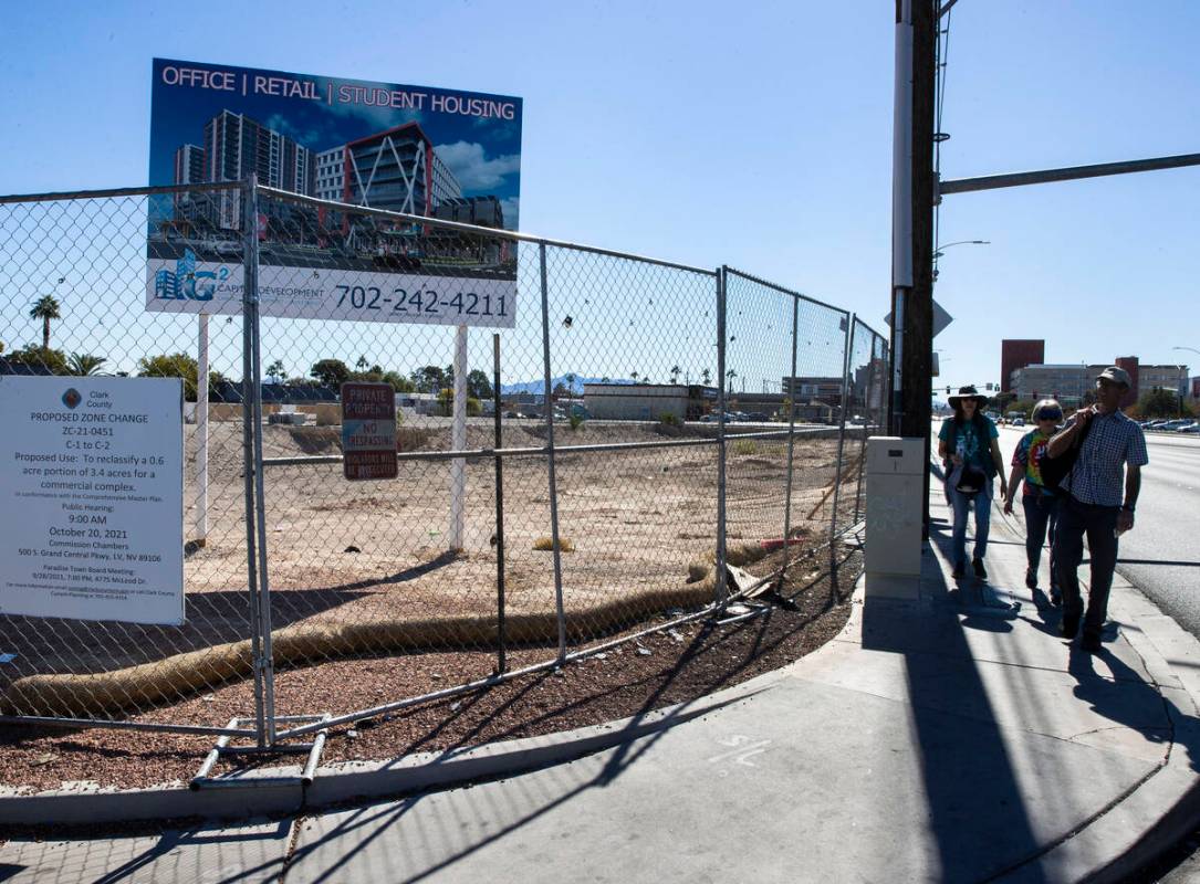 PedestrianS walk past a plot of land, left, near UNLV, on Wednesday, Oct. 27, 2021, in Las Vega ...