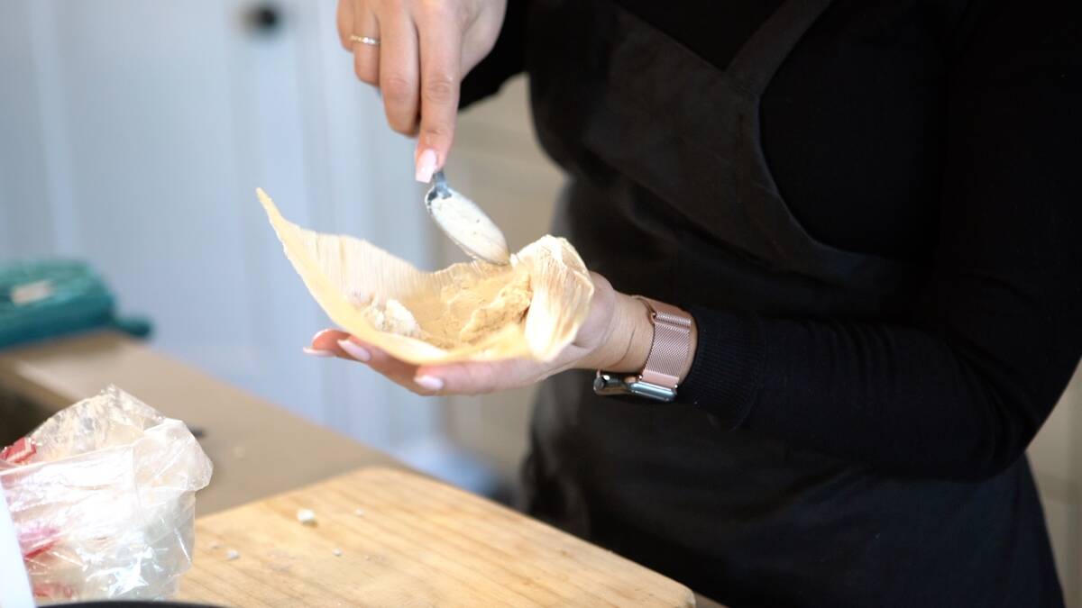 Maria Celeste Perez, who goes by Chef Le Che, fills a corn husk during preparation. (Ryan Smith ...
