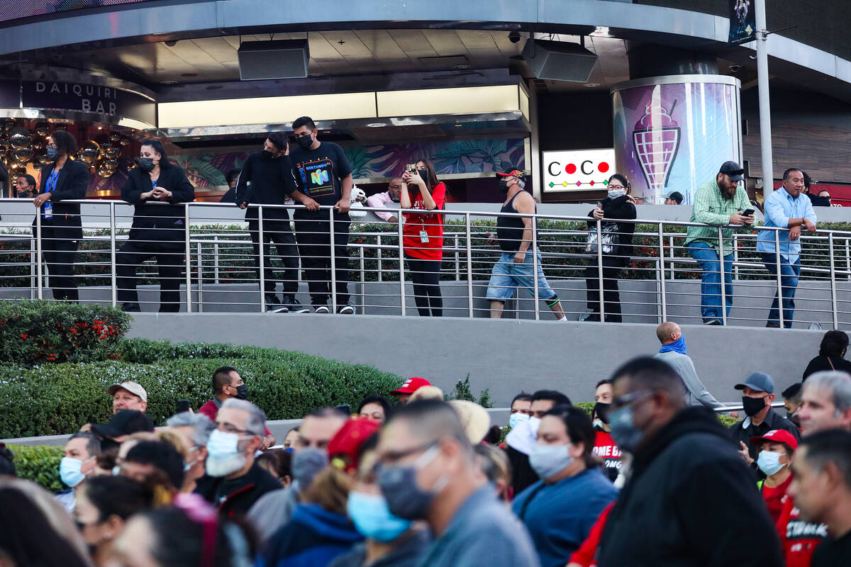 Bystanders watch a rally of the Culinary Workers Union to bring attention to the workers that a ...