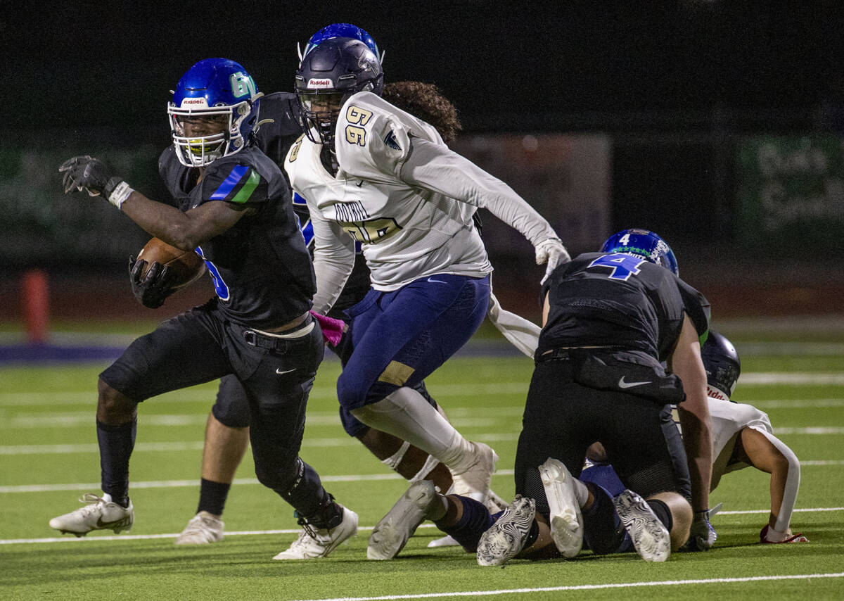 Green Valley running back Jaylen Mcknight (6) runs past Foothill defensive end Zarias Rose (99) ...