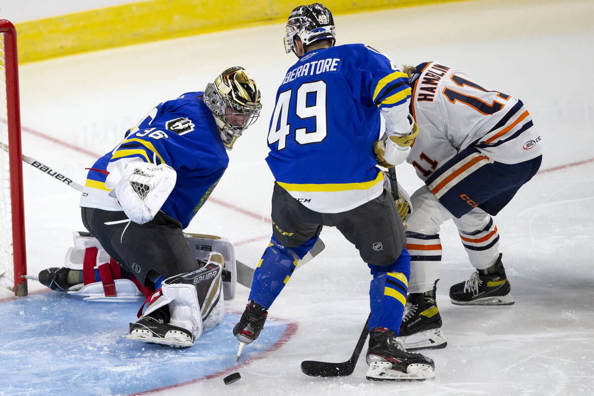 Henderson Silver Knights goaltender Logan Thompson (36) saves while defenseman Peter DiLiberato ...