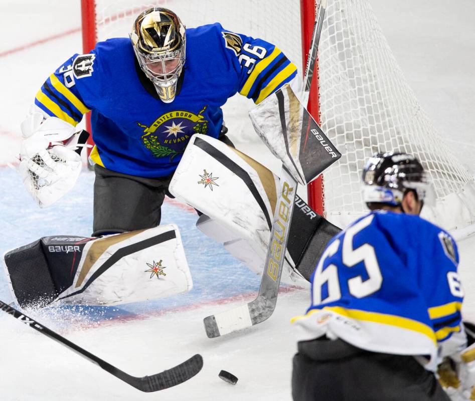 Henderson Silver Knights goaltender Logan Thompson (36) saves a shot on goal as defenseman Zack ...