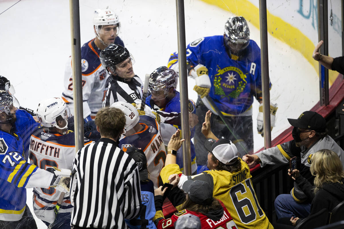 Henderson Silver Knights fans slam the glass as defenseman Derrek Pouliot (51) and Bakersfield ...