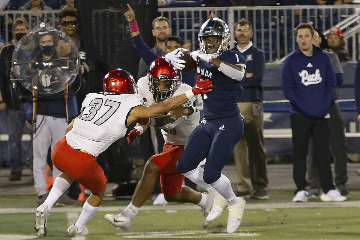 Nevada's Melquan Stovall (1) tries to get away from UNLV's Davone Walden Jr. (37) during the fi ...