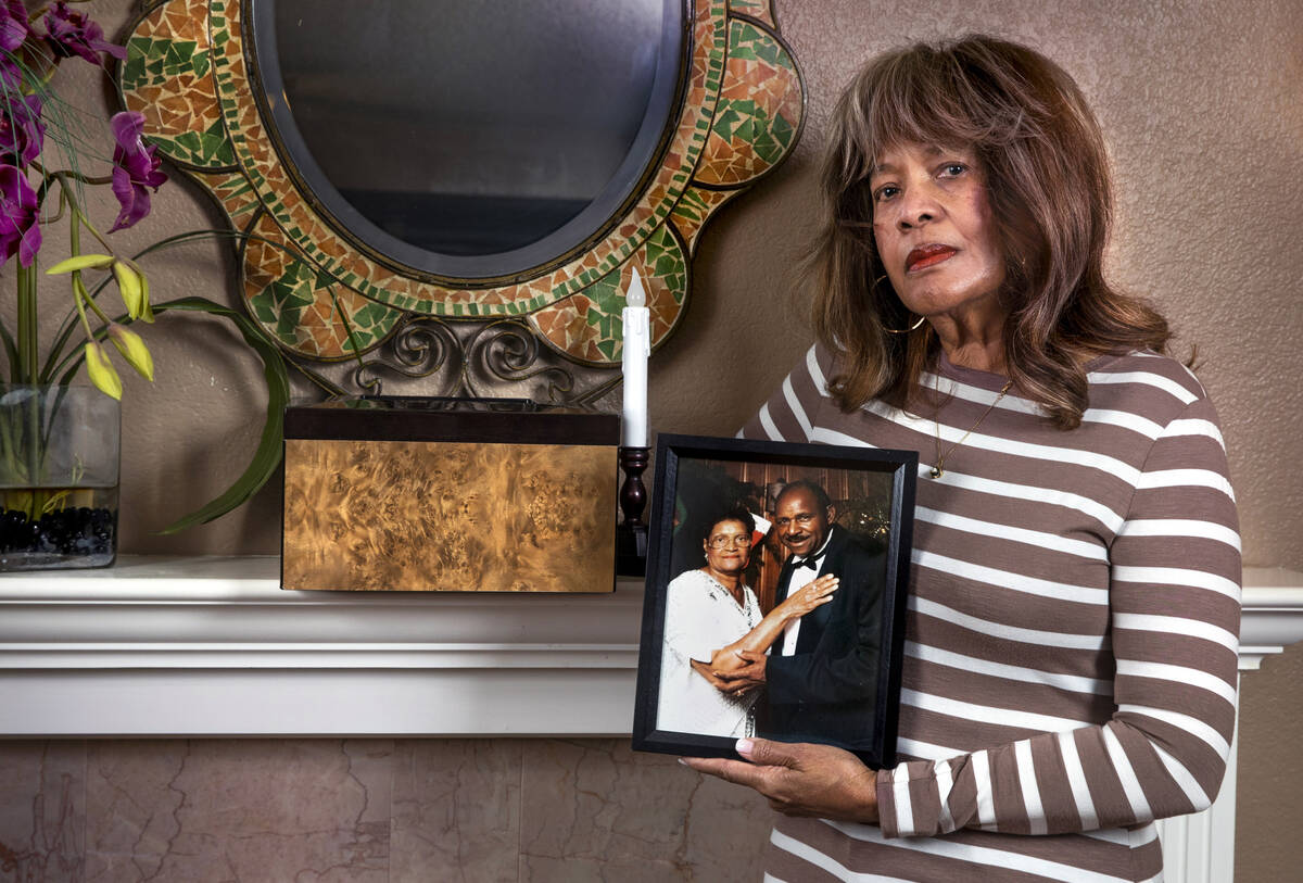Sylvia Smith holds a picture of her parents Geneva and George Woods near the fireplace mantel w ...