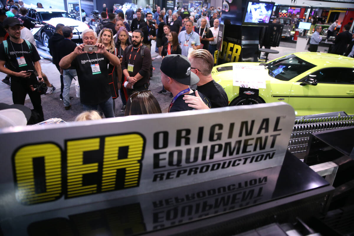 People visit the Original Equipment Reproduction booth during the SEMA show at the Las Vegas Co ...
