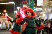 Performers wave to the crowd as the Downtown Summerlin Holiday Parade makes its way through Fes ...