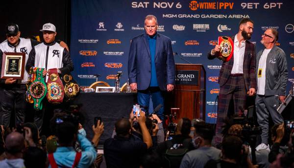 Boxer Canelo Alvarez holds his belts with trainer Eddy Reynoso, left, and Caleb Plant beside hi ...