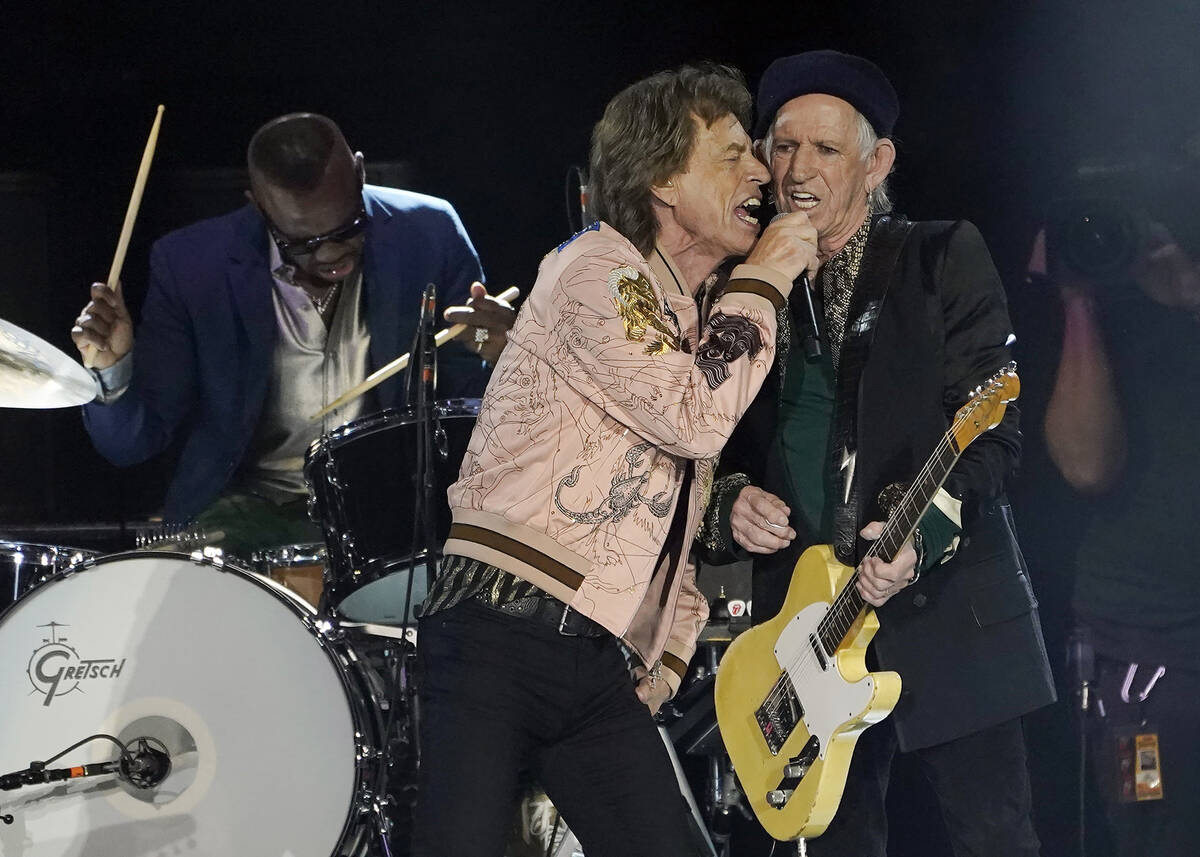 Mick Jagger, center, and Keith Richards of the Rolling Stones share vocals during the band's pe ...