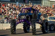 A lifted car passes the fans packed into the stands during the car Cruise at SEMA Ignited from ...