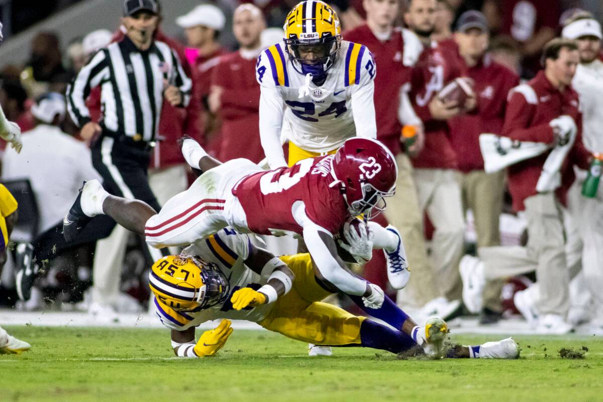 Alabama running back Roydell Williams (23) dives over LSU safety Jay Ward (5) during the first ...