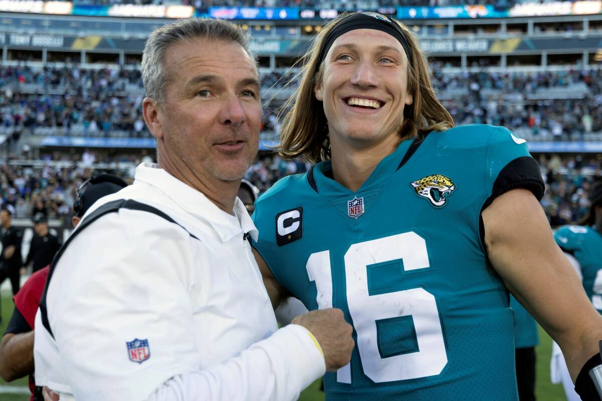 Jacksonville Jaguars head coach Urban Meyer, left, and quarterback Trevor Lawrence (16) celebra ...