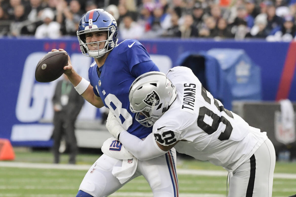 Las Vegas Raiders' Solomon Thomas (92) hits New York Giants' Daniel Jones (8) as he throws a pa ...