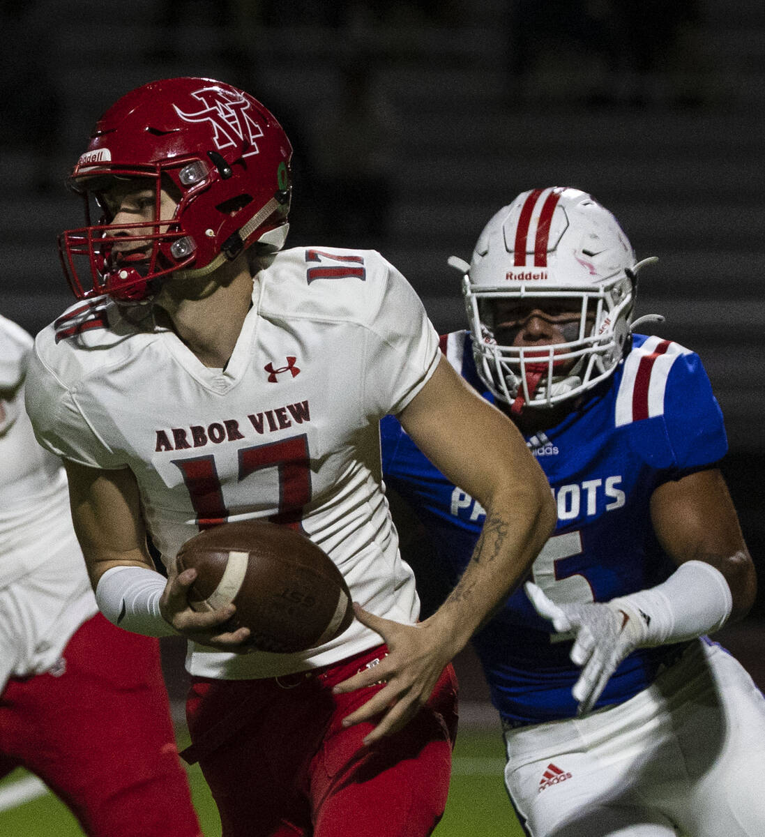 Arbor View High quarterback Kyle Holmes (17) chased by Liberty High defensive end Anthony Jones ...